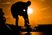 An inviting lifestyle shot of a person tying their running shoes outdoors at sunrise, ready for a workout.