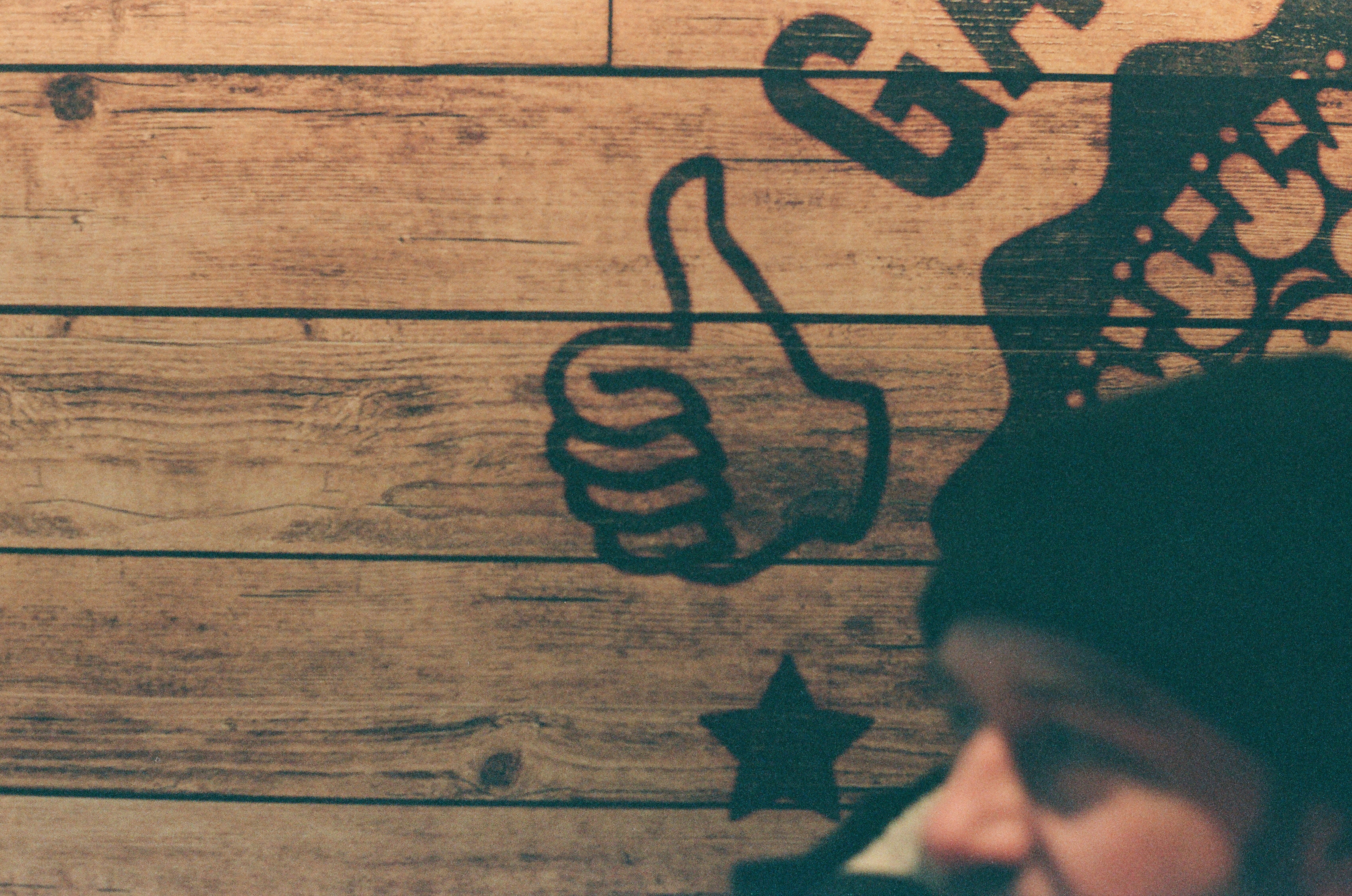 a person standing in front of a wooden wall