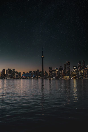 A sleek Toronto skyline at dusk with subtle AI data overlays glowing softly.