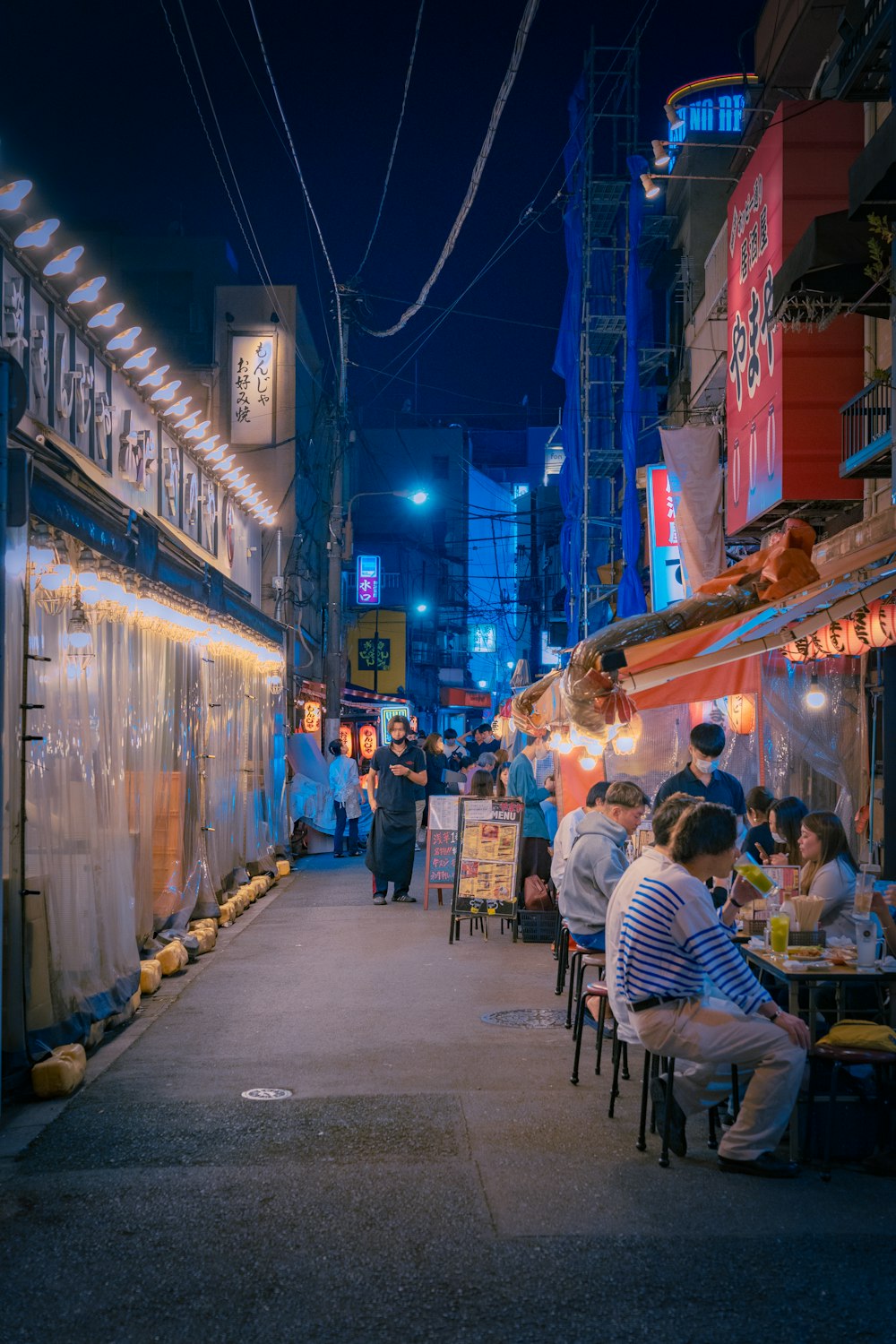 a group of people sitting at a table in a street