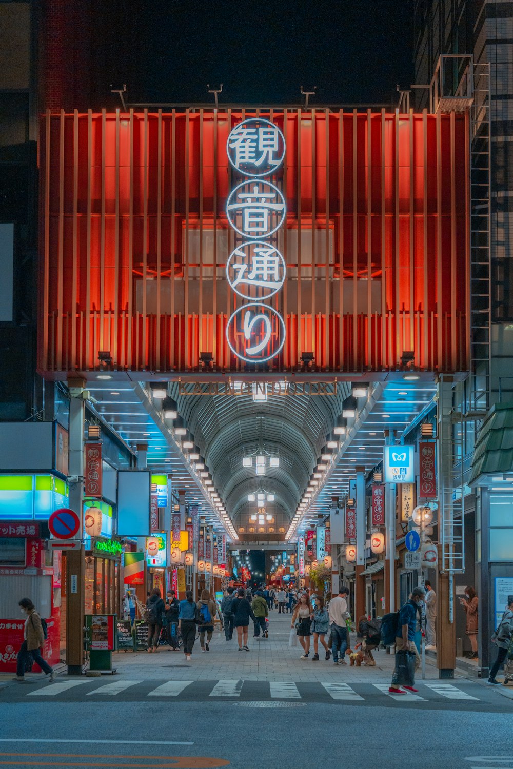 a group of people walking down a street next to tall buildings