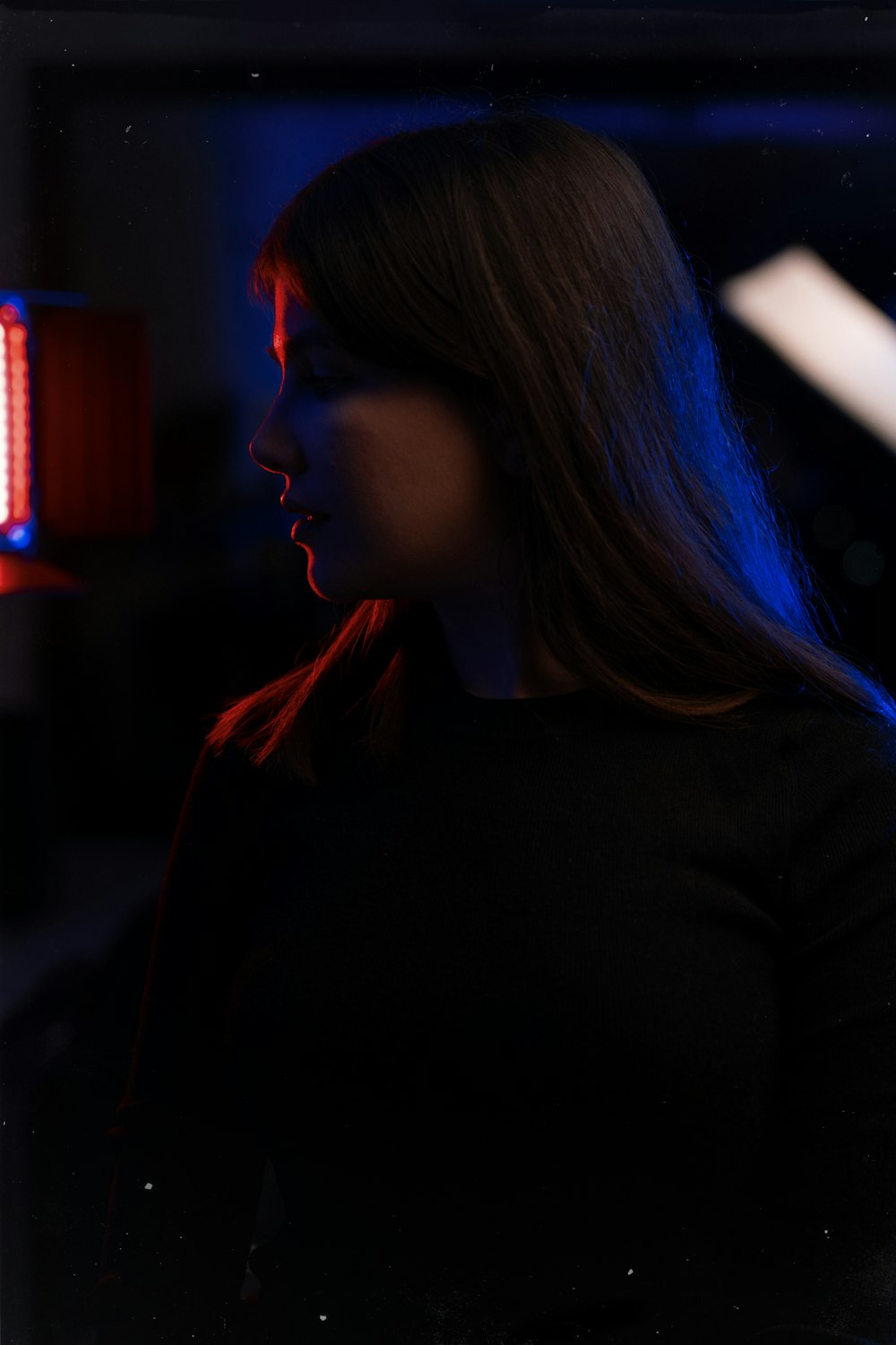 a woman standing in front of a red light