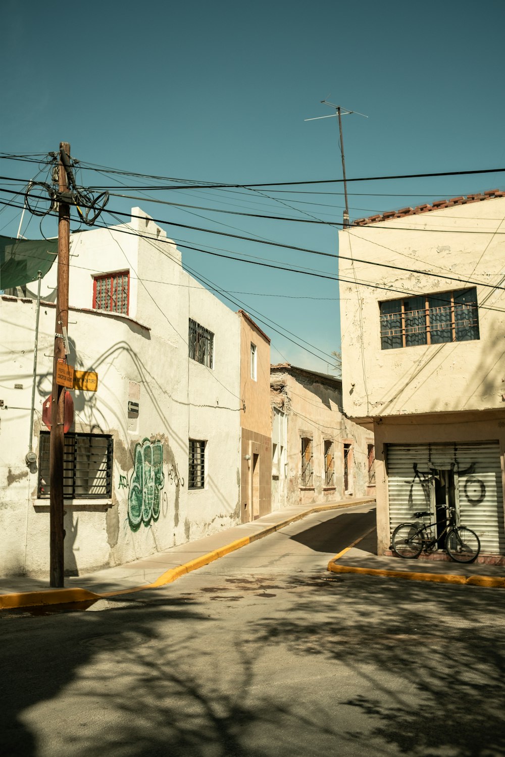 a street corner with a building and a bicycle parked on the side of the street