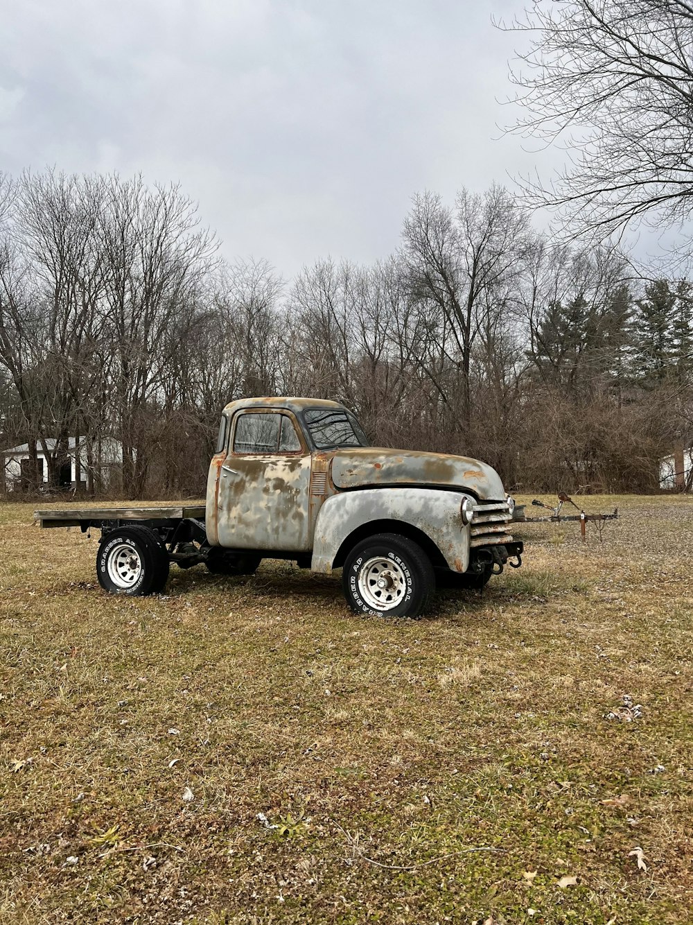 an old rusty truck parked in a field