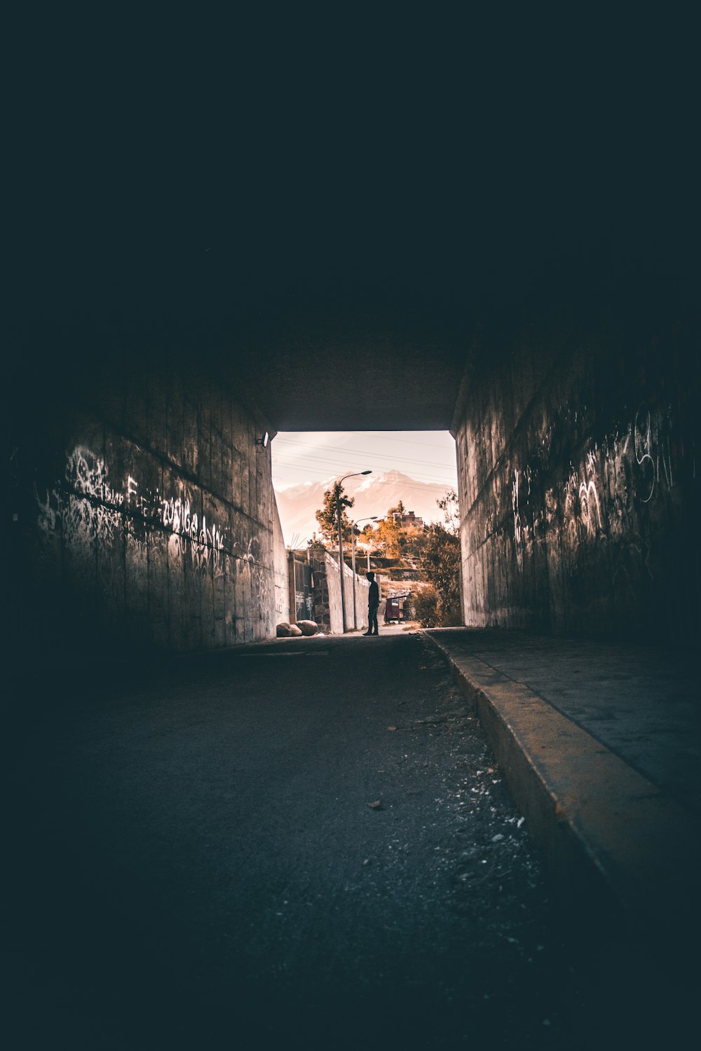 a dark tunnel with graffiti on the walls