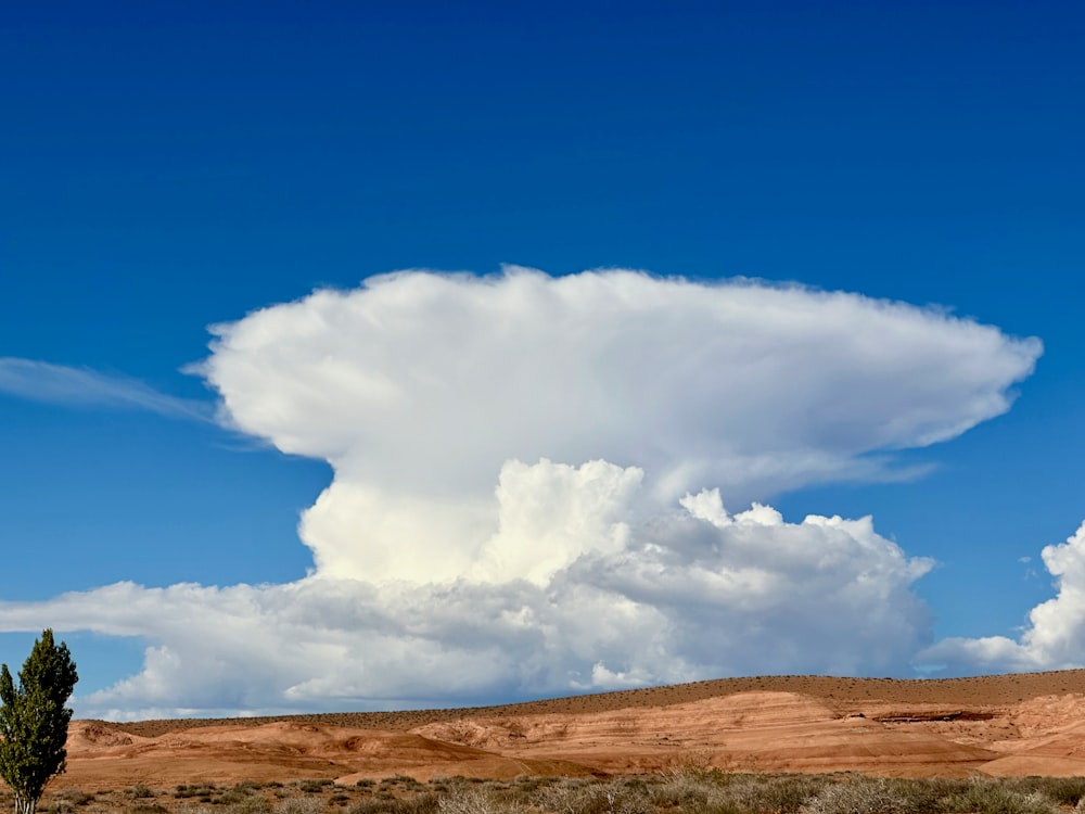 a large cloud in the sky over a desert