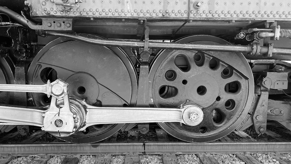 a black and white photo of the wheels of a train