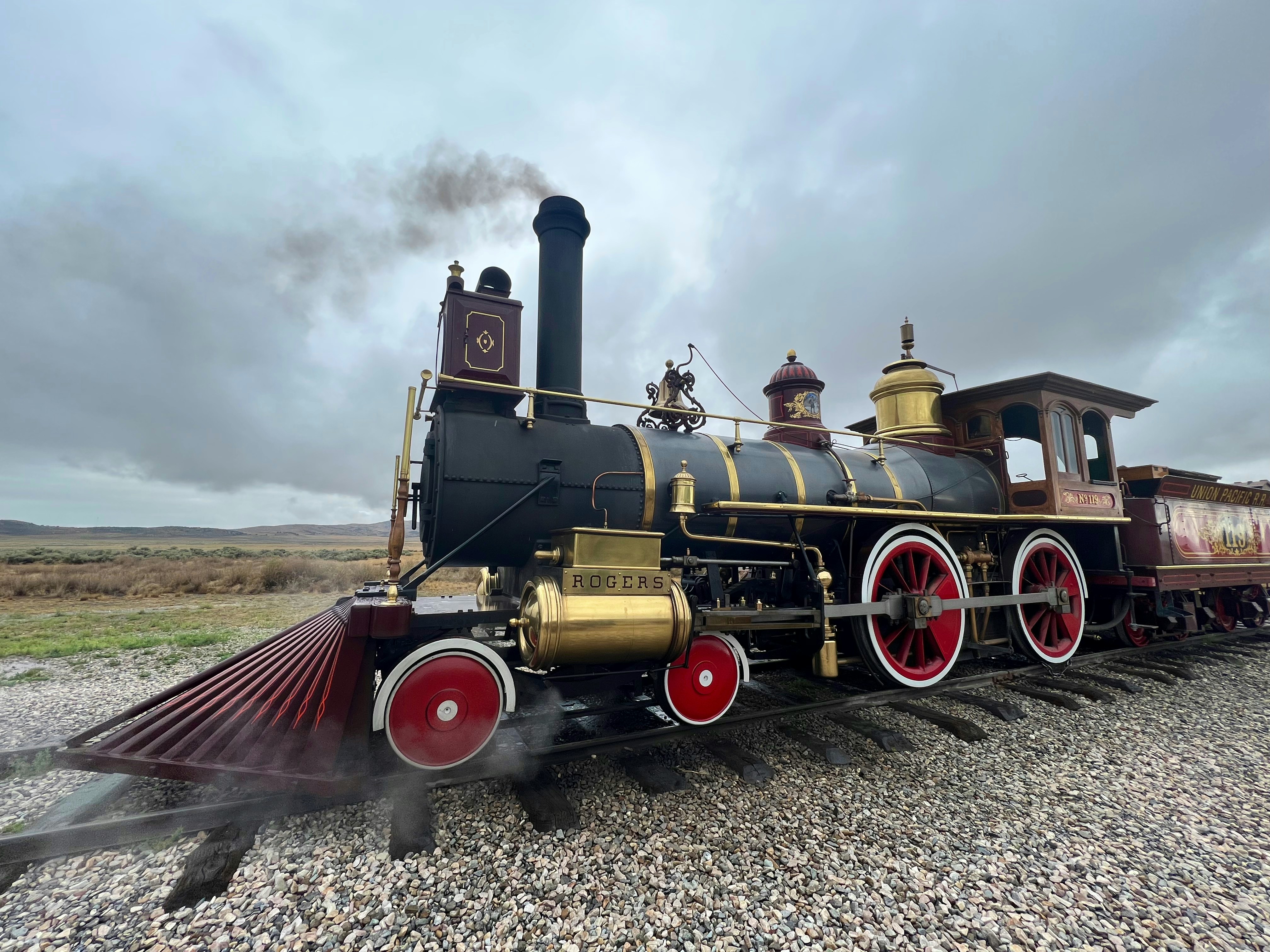an old fashioned steam engine on a gravel road