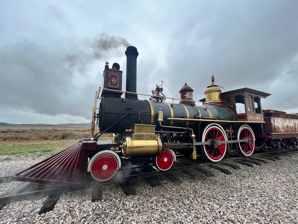 an old fashioned steam engine on a gravel road
