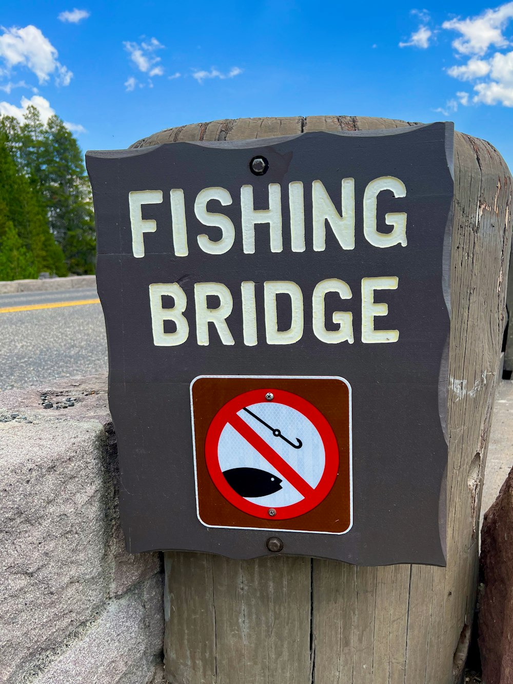 a sign on a wooden post that says fishing bridge