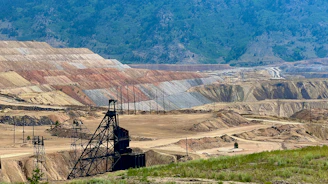 a view of a large open pit with a mountain in the background