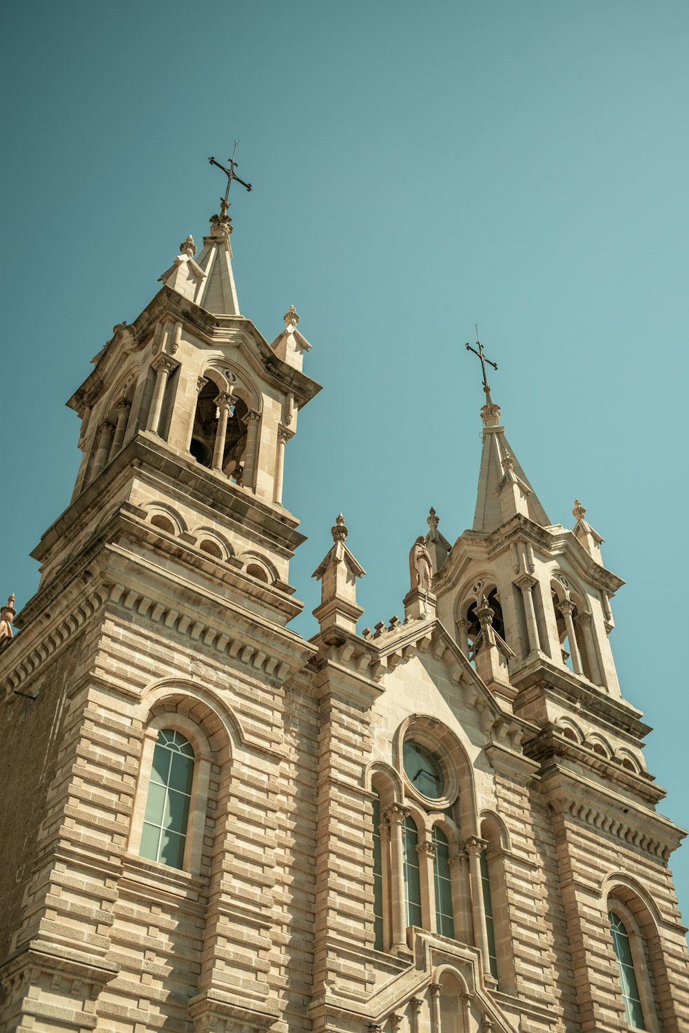 a church with two steeples and a cross on top