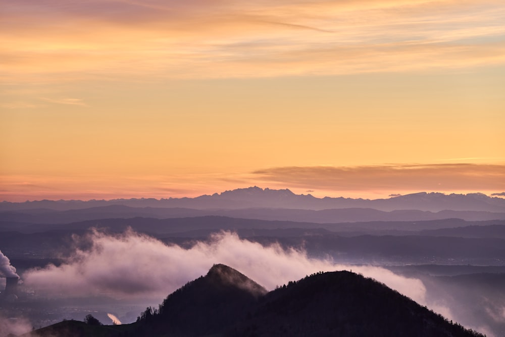 Una vista de una cadena montañosa con nubes en primer plano