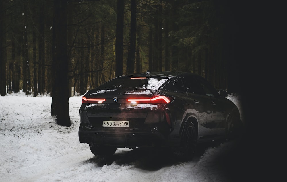 a car is parked in the snow in the woods