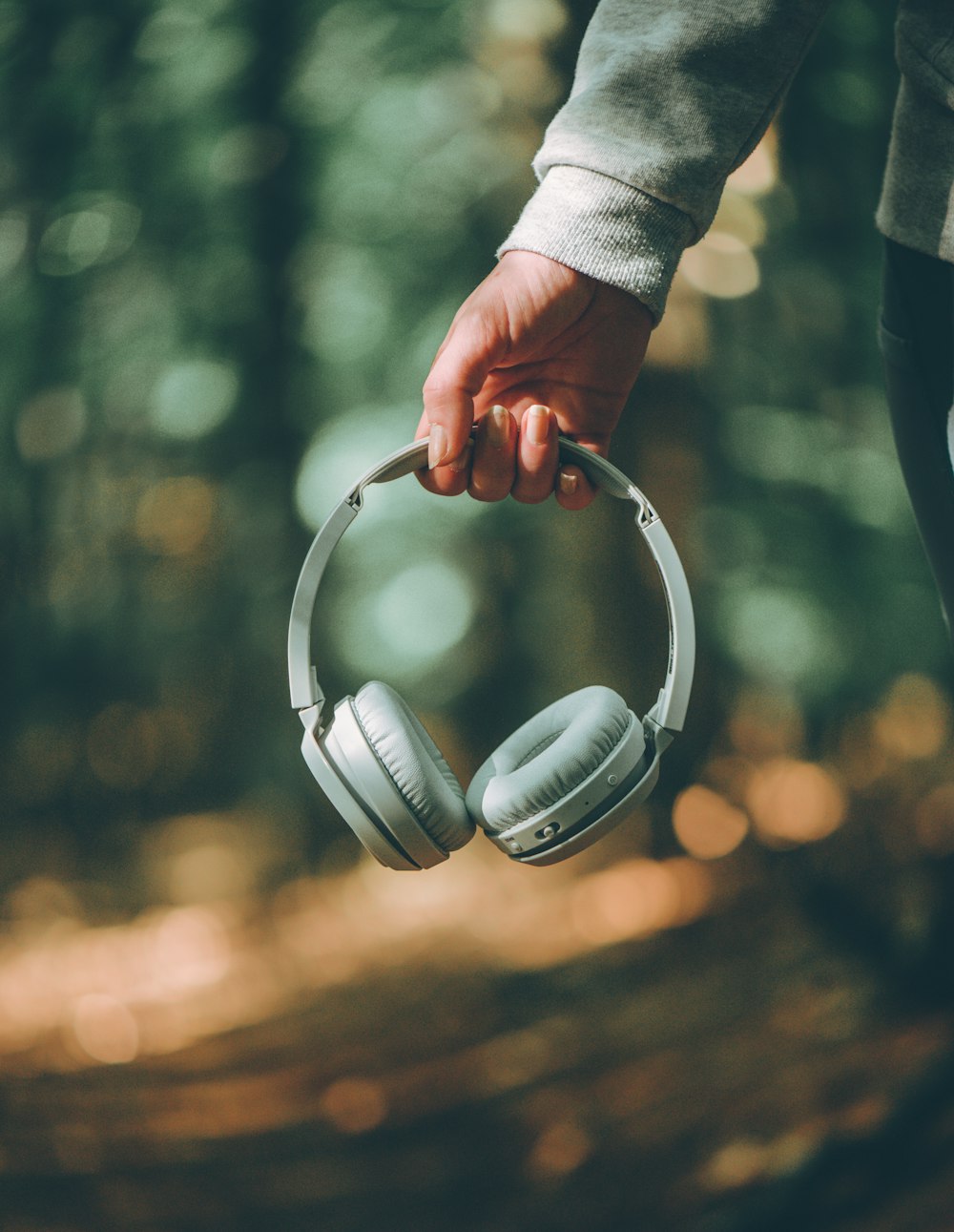 a person holding a pair of headphones in their hand