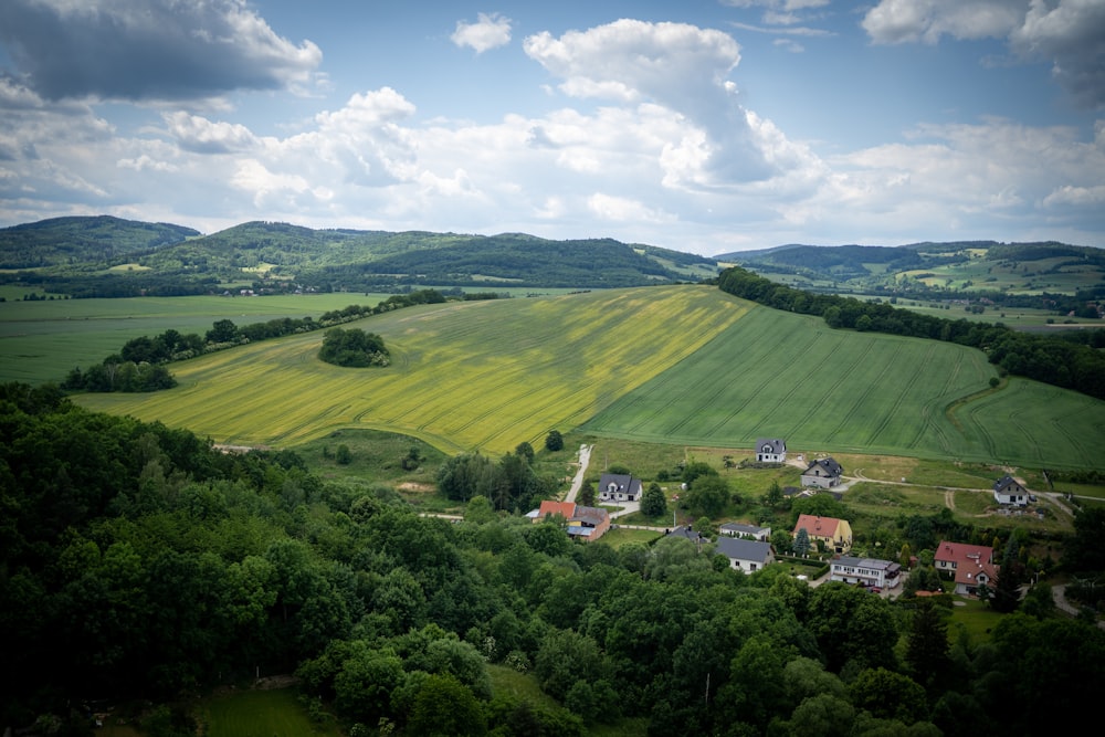 an aerial view of a green countryside with houses