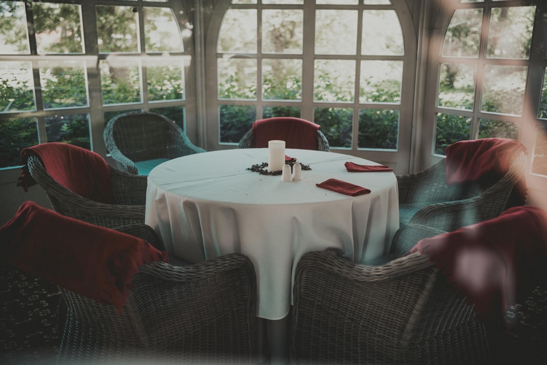 a table with a white table cloth and red napkins,
