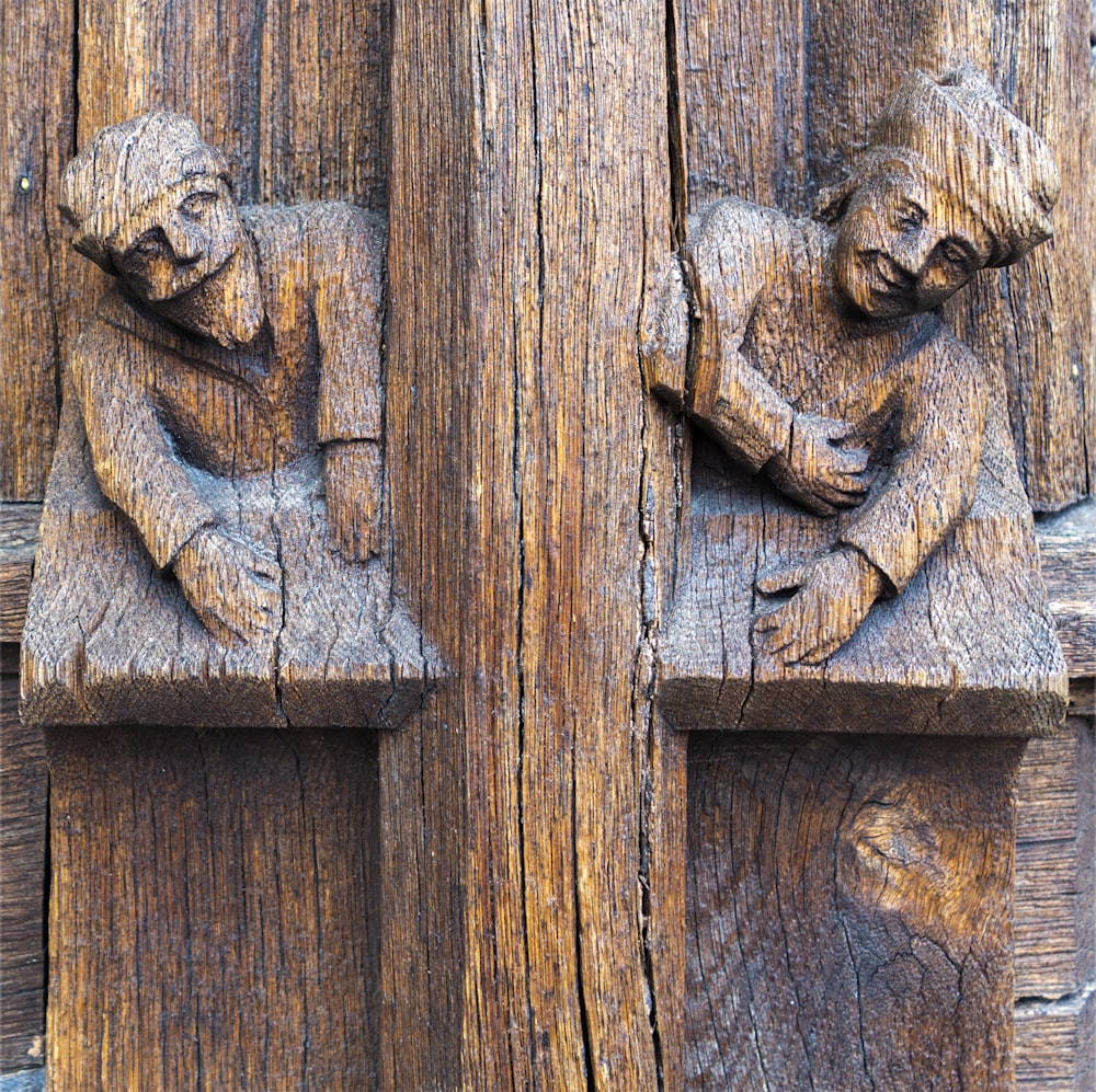 a close up of a wooden carving of two people