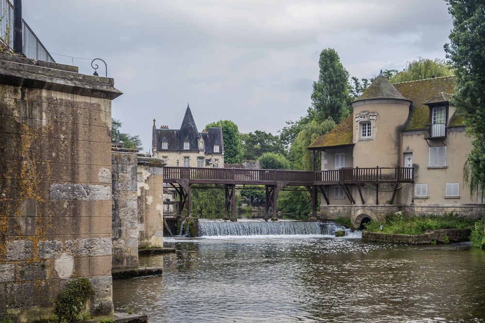 a river running under a bridge next to a tall building