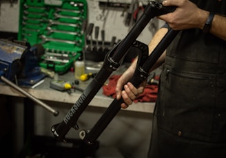 a man holding a bike in a garage