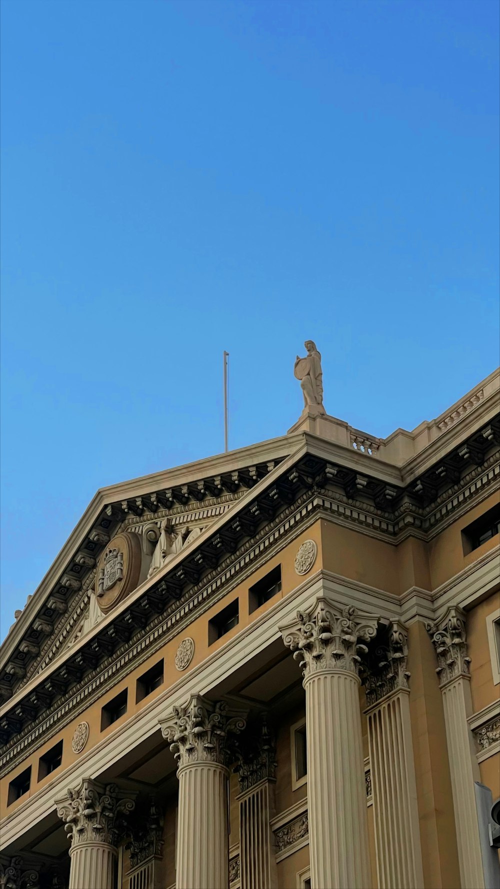 a tall building with columns and a clock on top