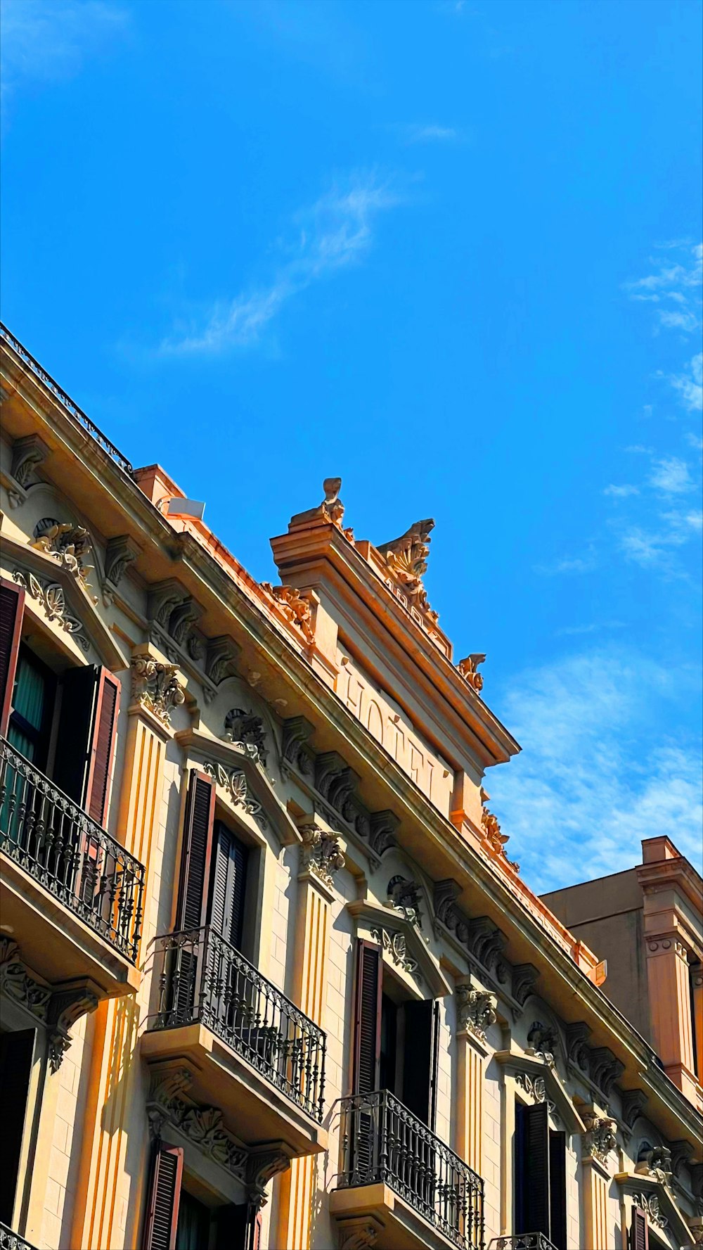 um edifício com varandas e um relógio no topo dele