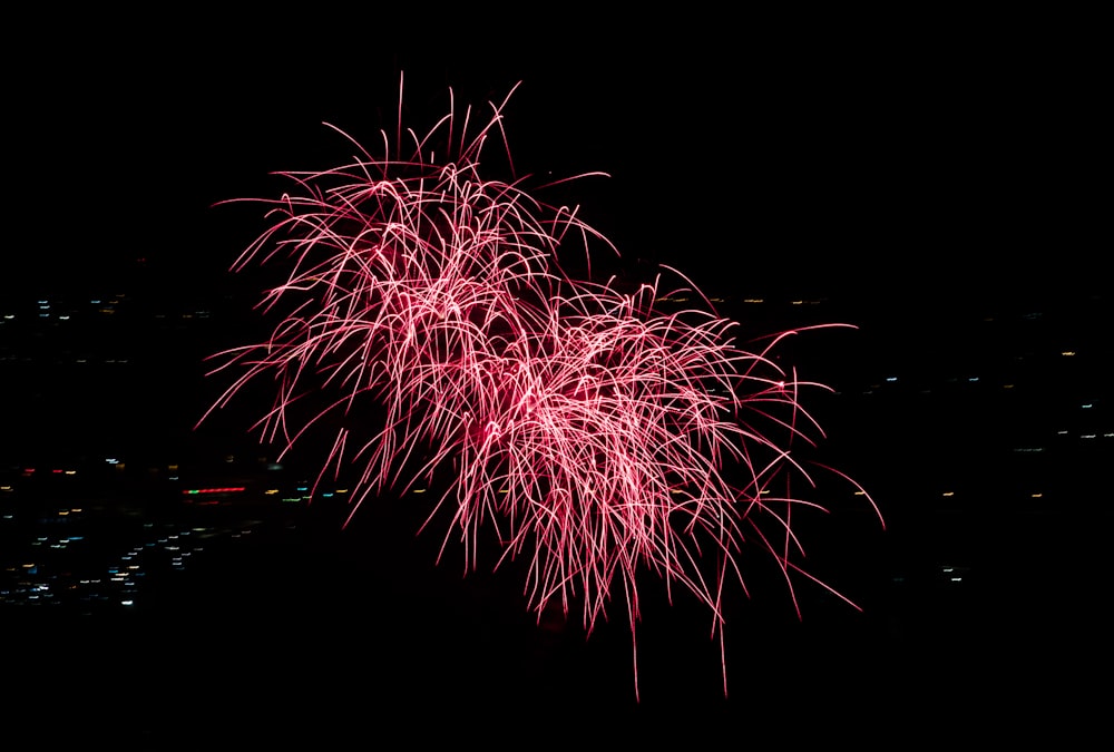 a red fireworks is lit up in the night sky