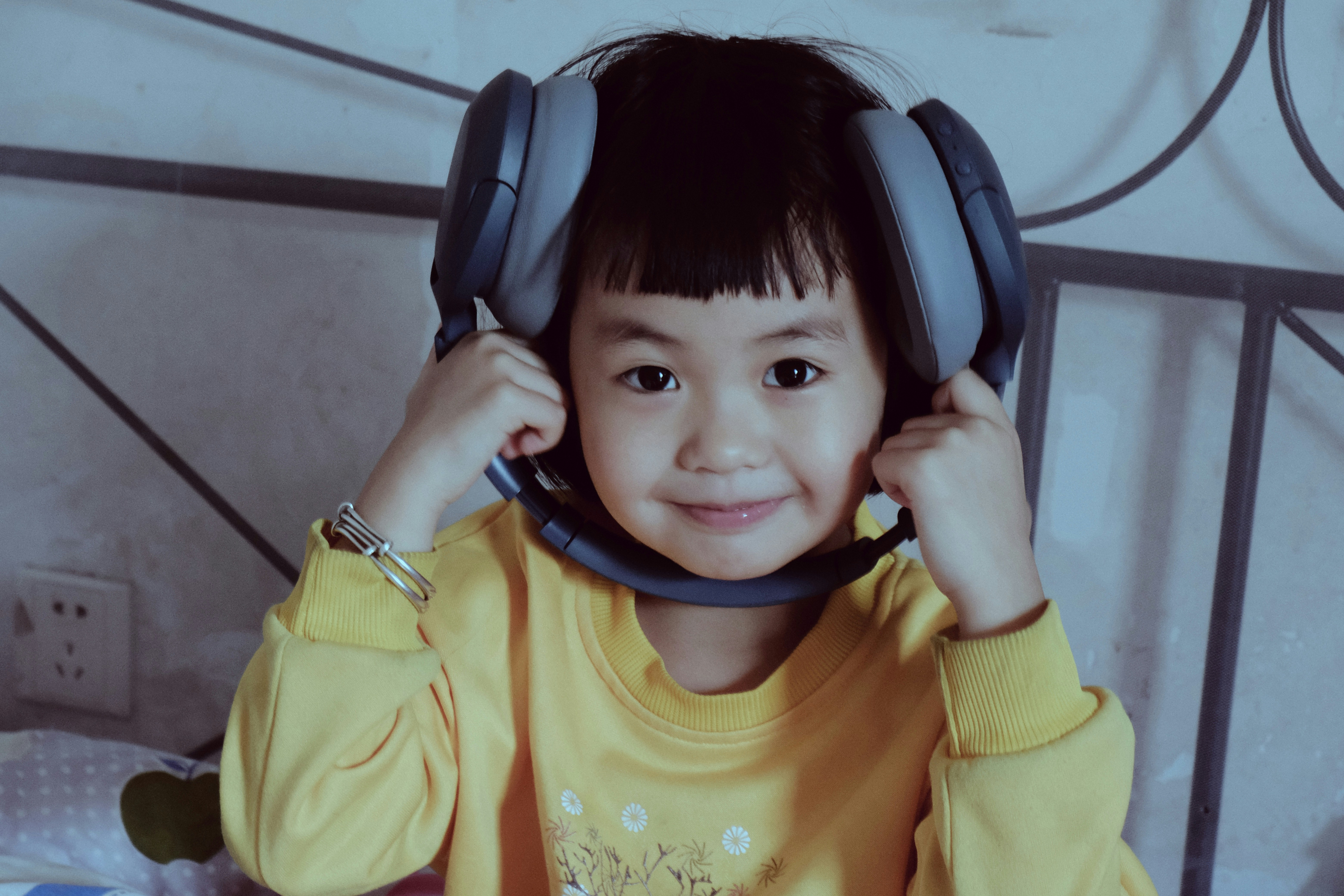 Child with noise-canceling headphones smiling at a mascot