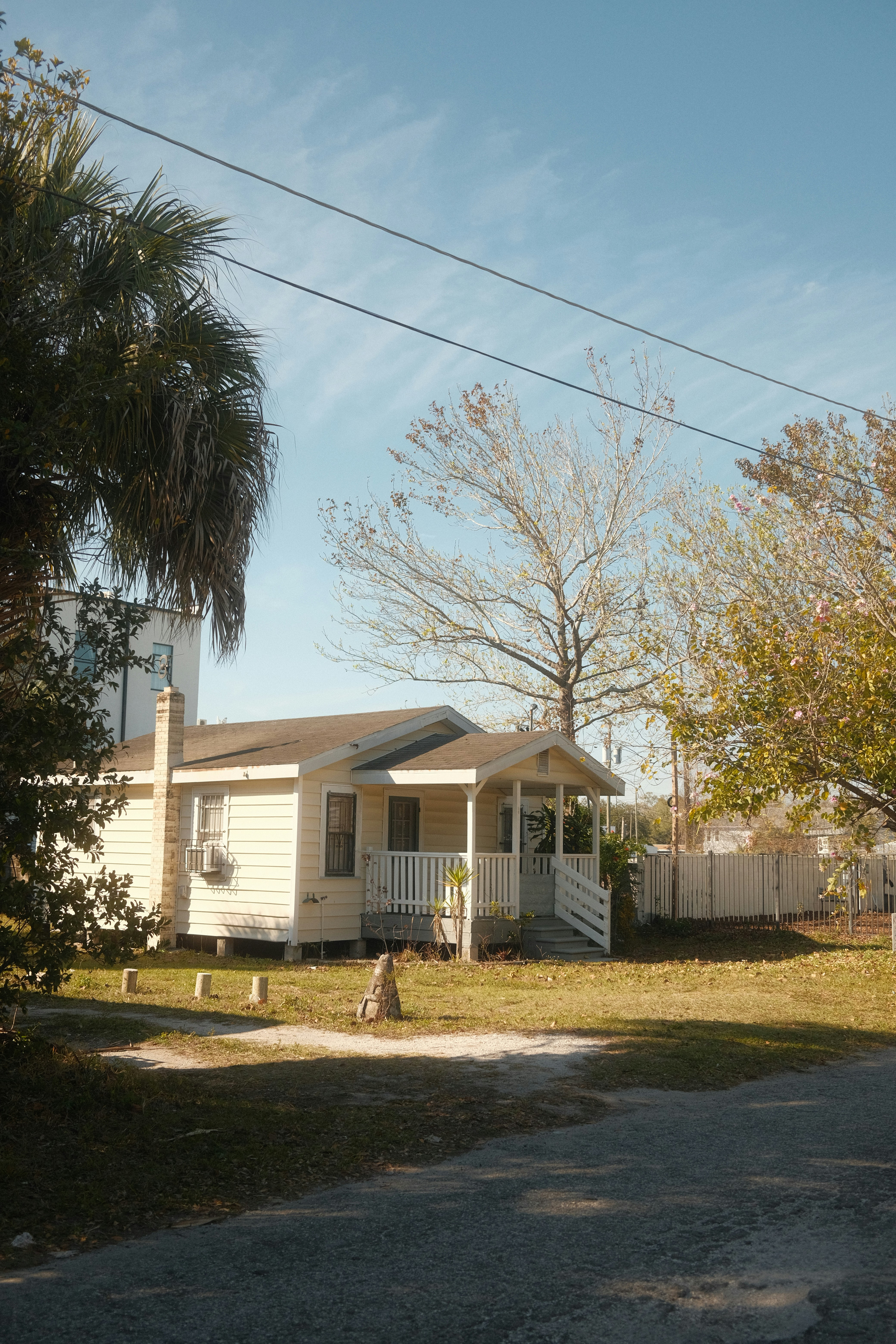 a house with a white picket fence and trees in front of it