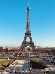 A picturesque view of the Eiffel Tower with surrounding Parisian cityscape under a clear blue sky.