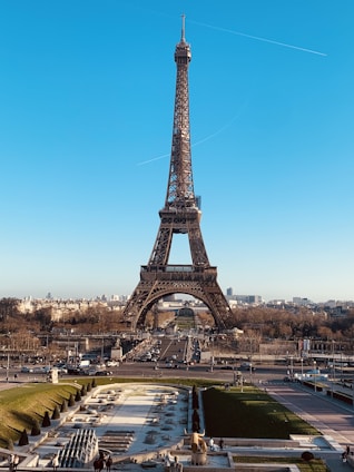 A picturesque view of the Eiffel Tower with surrounding Parisian cityscape under a clear blue sky.
