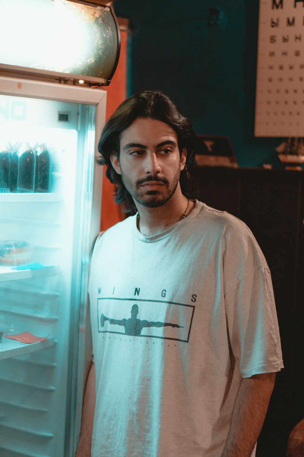 a man standing in front of an open refrigerator