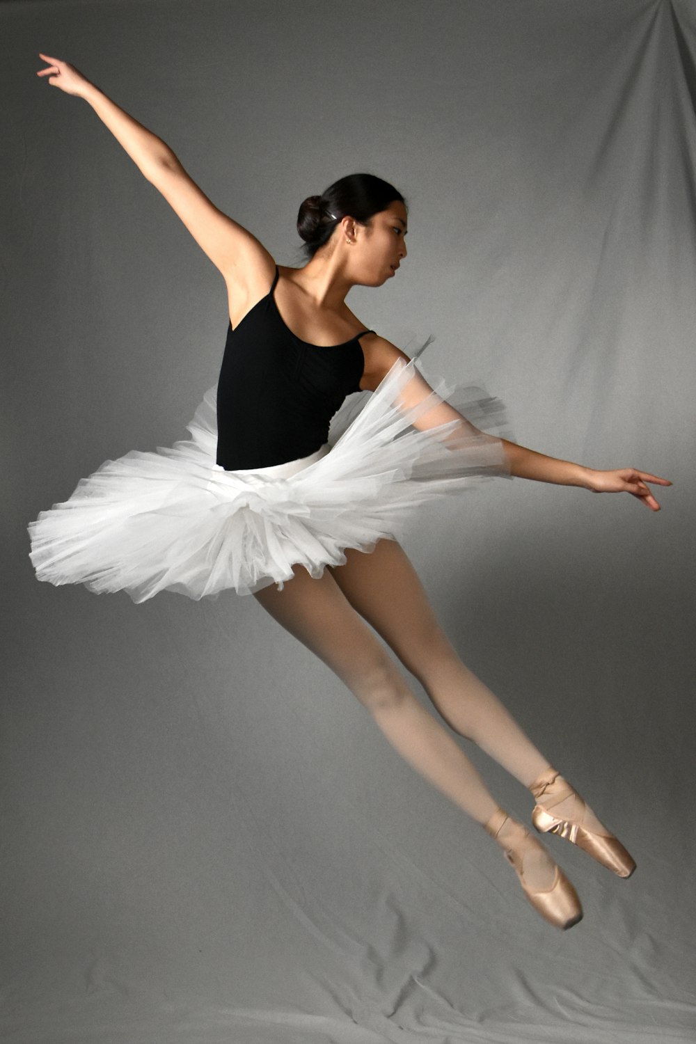 a ballerina in a black leotard and white tutu