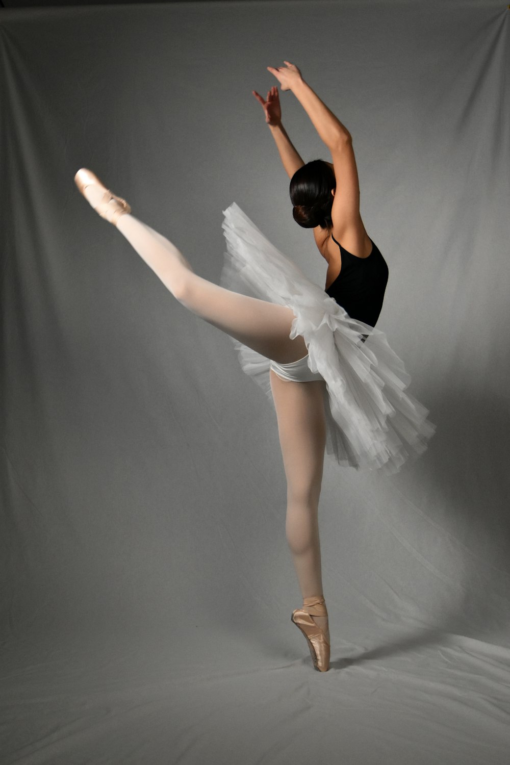 Una ballerina in body nero e tutù bianco