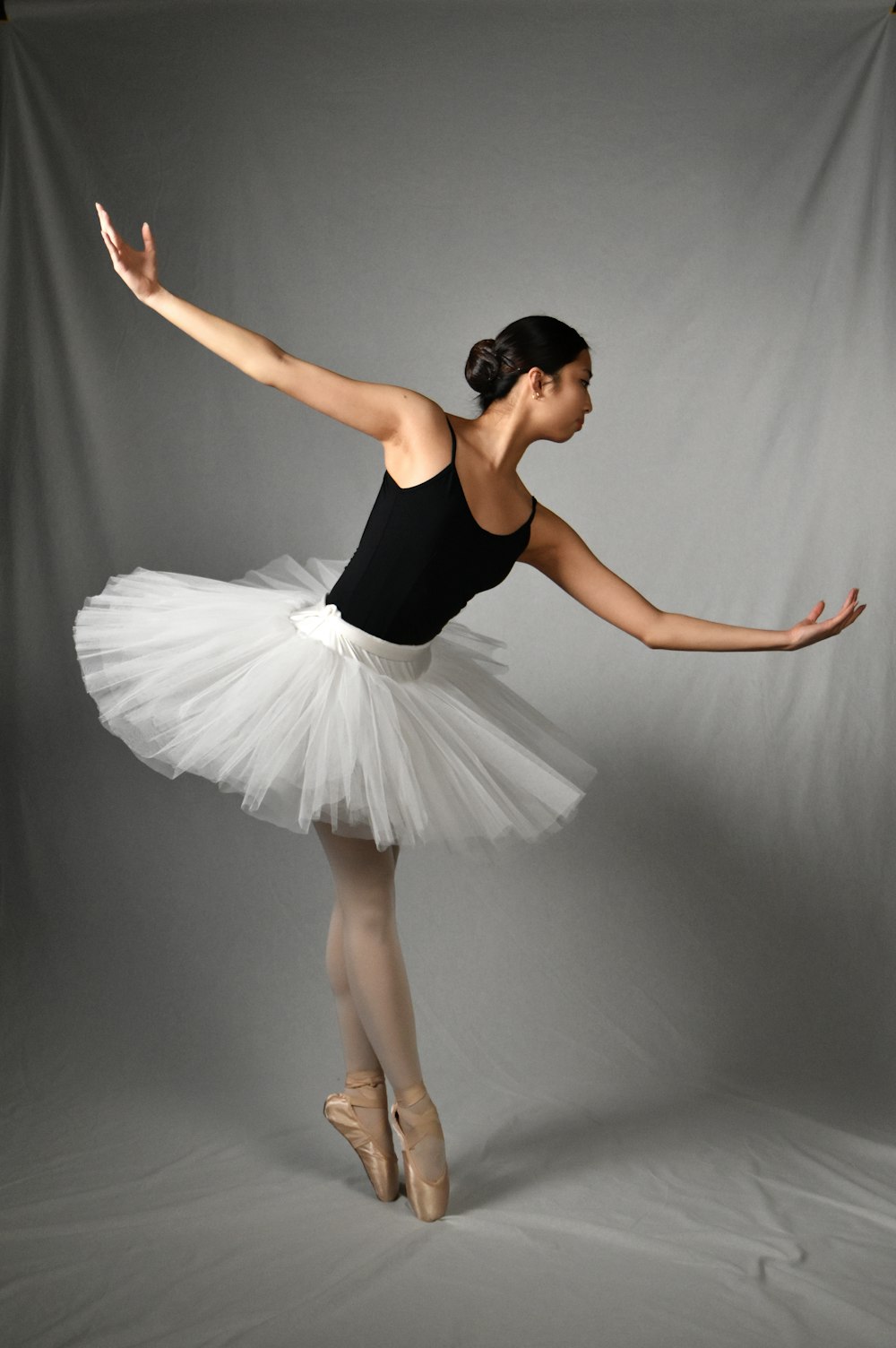 a woman in a white tutu and ballet shoes