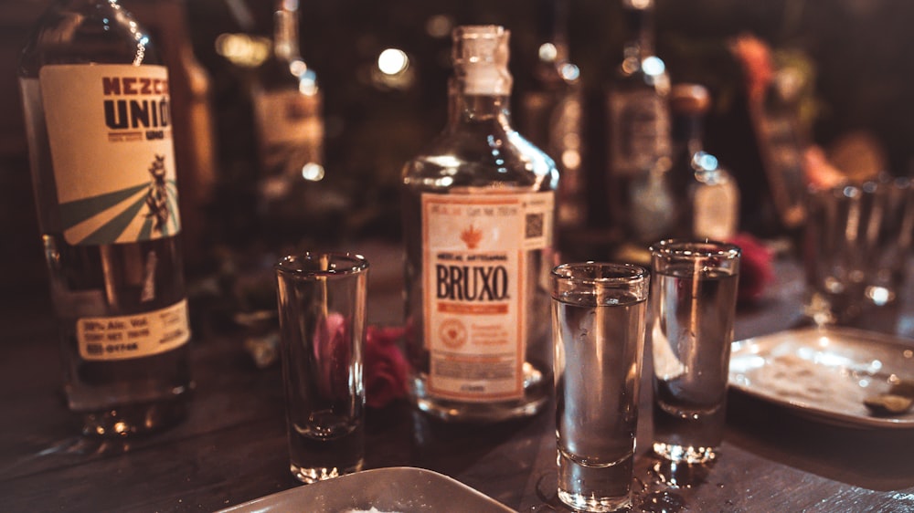 a table topped with glasses and bottles of alcohol