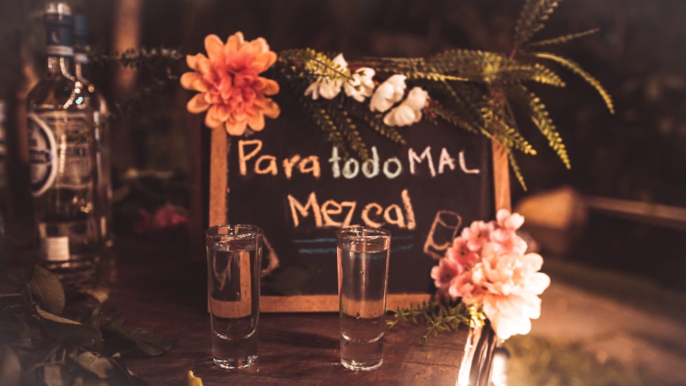 a wooden table topped with glasses and a sign