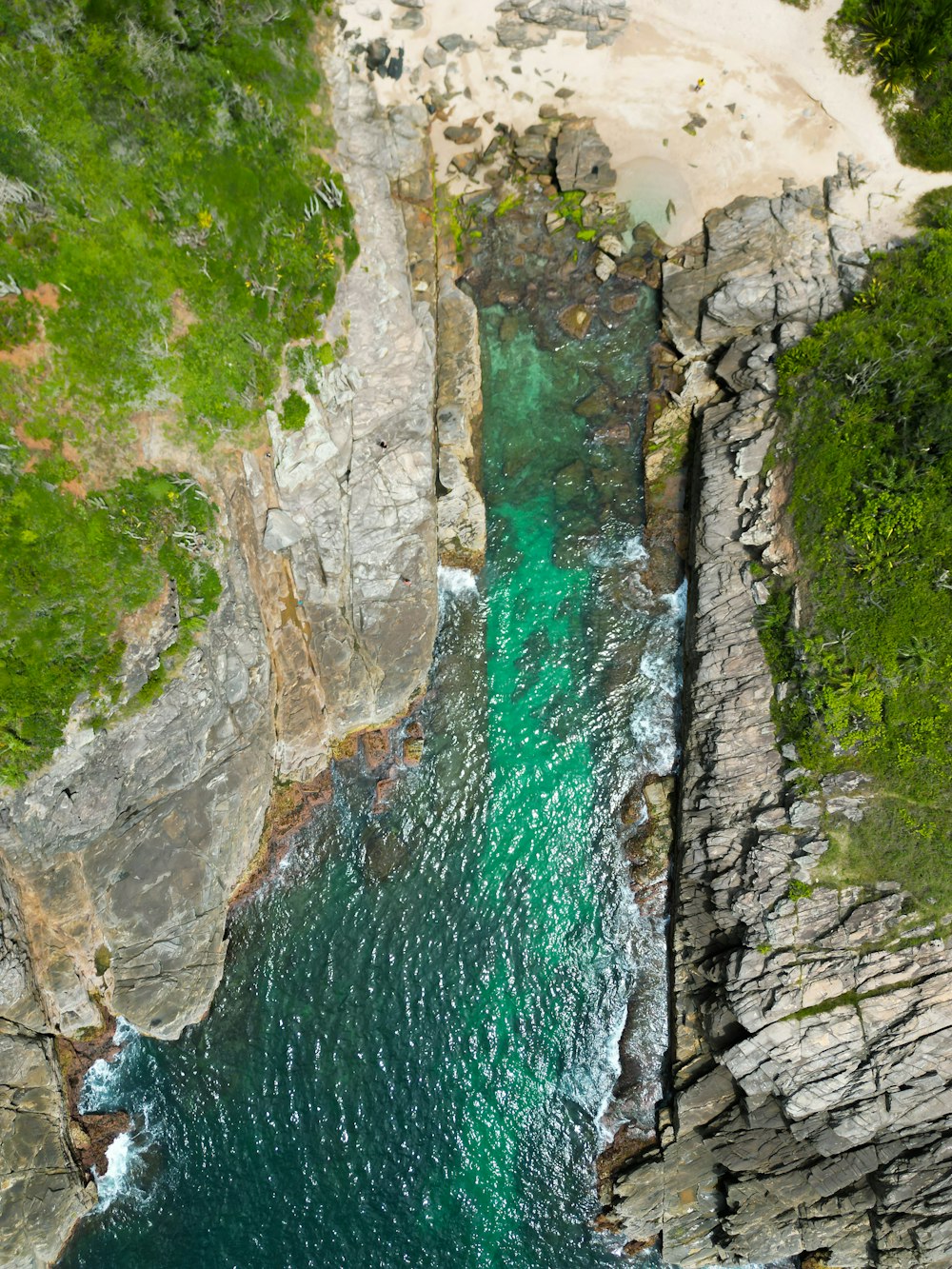 an aerial view of a body of water near a cliff