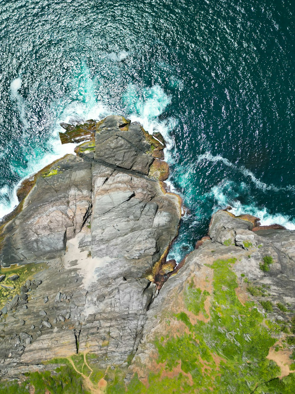 a bird's eye view of the ocean and rocks