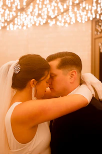 A bride and groom sharing a quiet, intimate moment surrounded by dark, elegant decor.