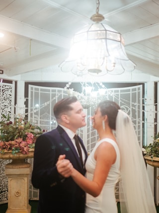a bride and groom standing in front of a chandelier