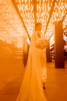 A cinematic shot of a bride walking down a beautifully lit aisle.