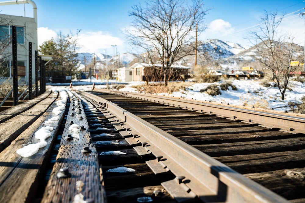 a train track with snow on it and a building in the background