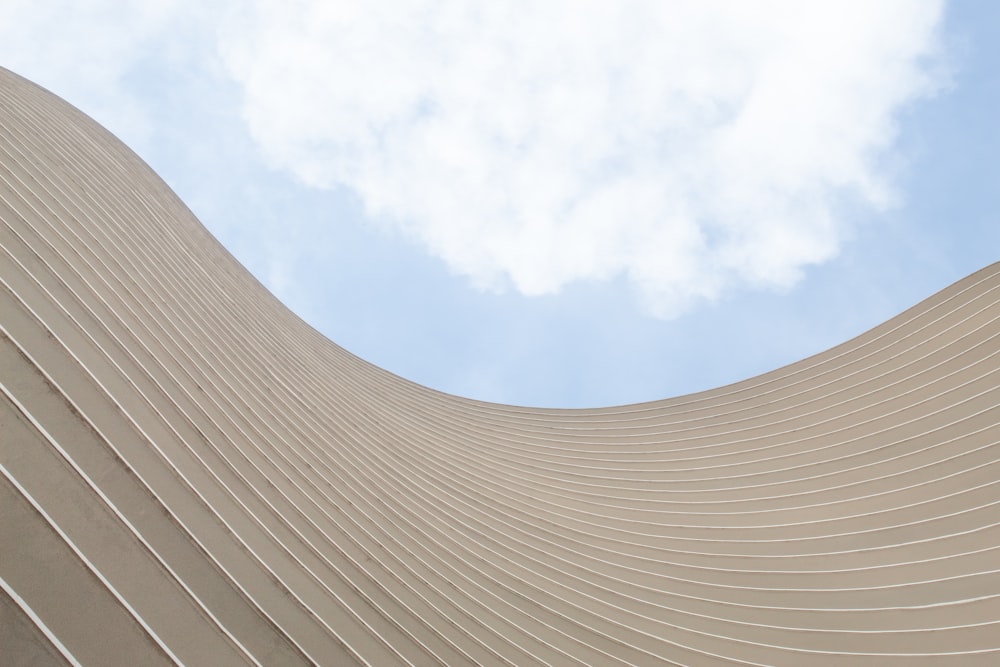 a curved building with a blue sky in the background