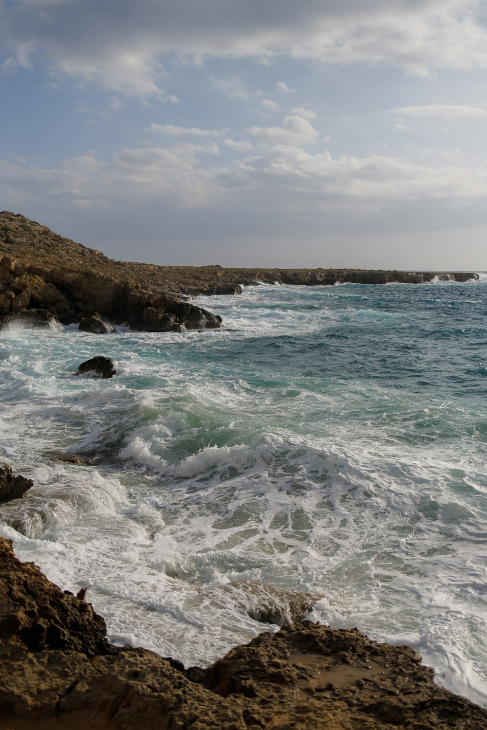 a rocky shore with waves crashing against the rocks