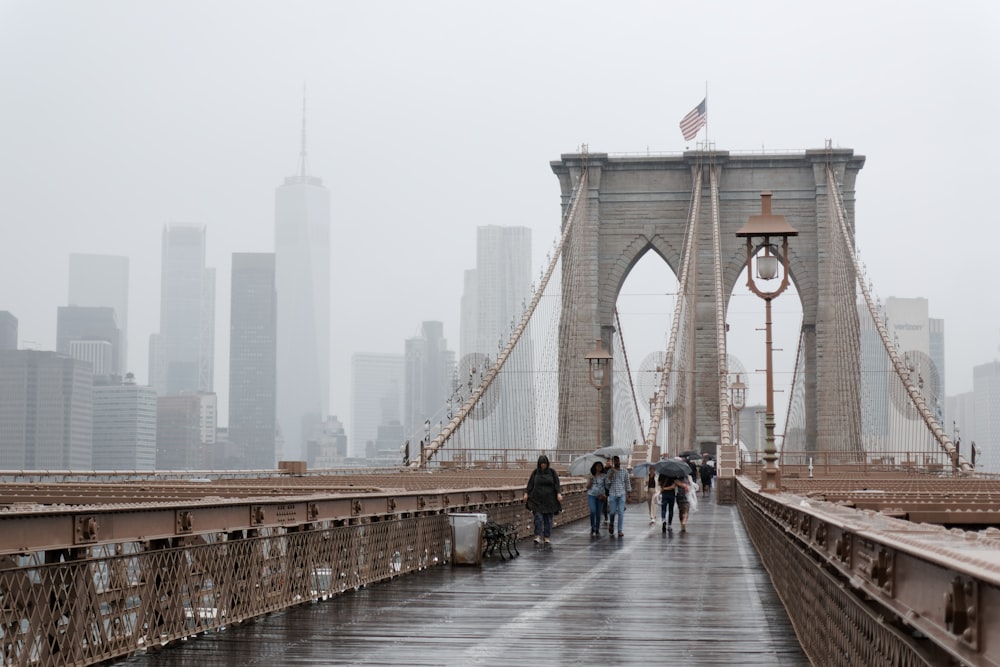 a group of people walking across a bridge