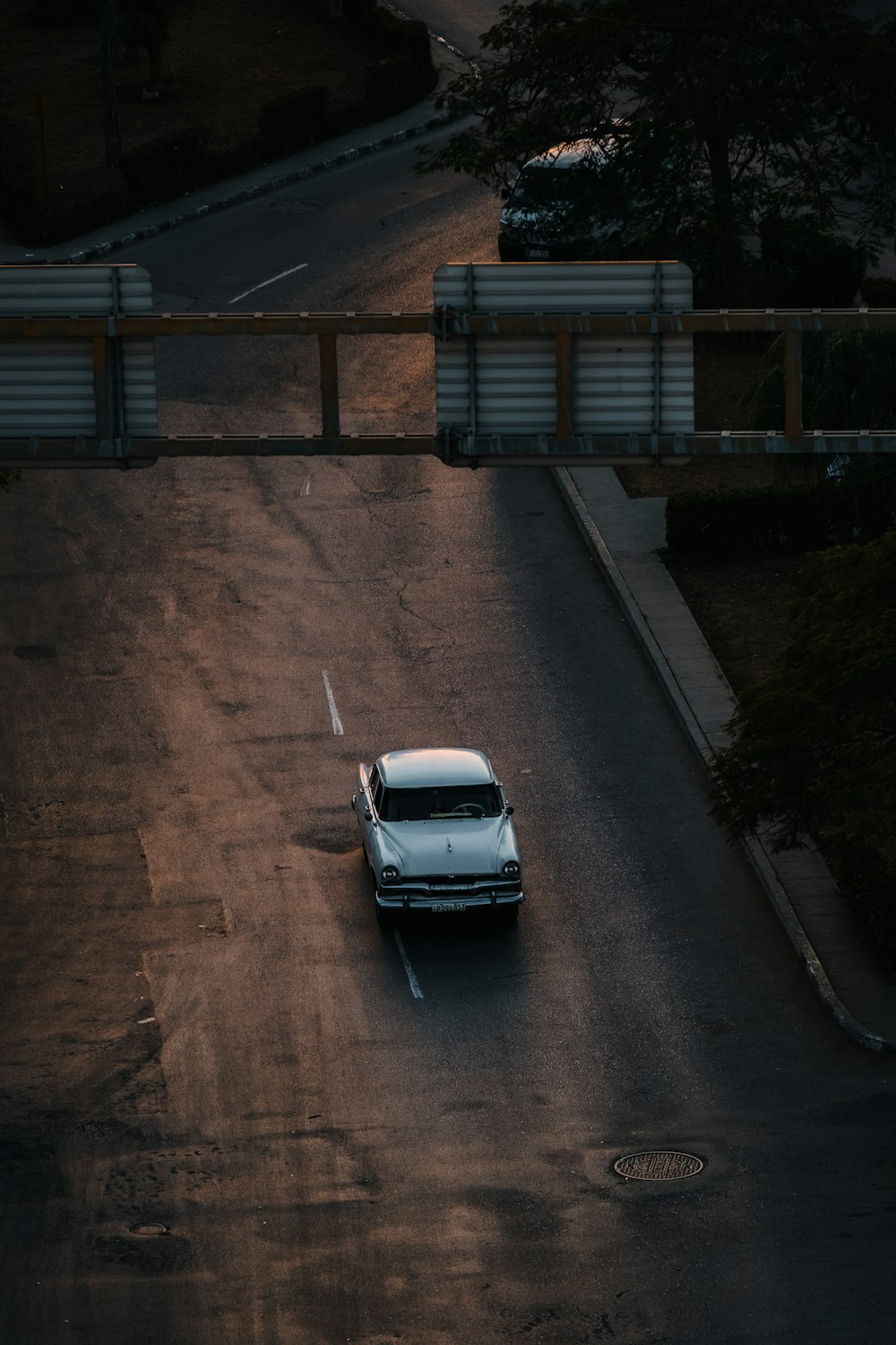 a white car driving down a street next to a bridge