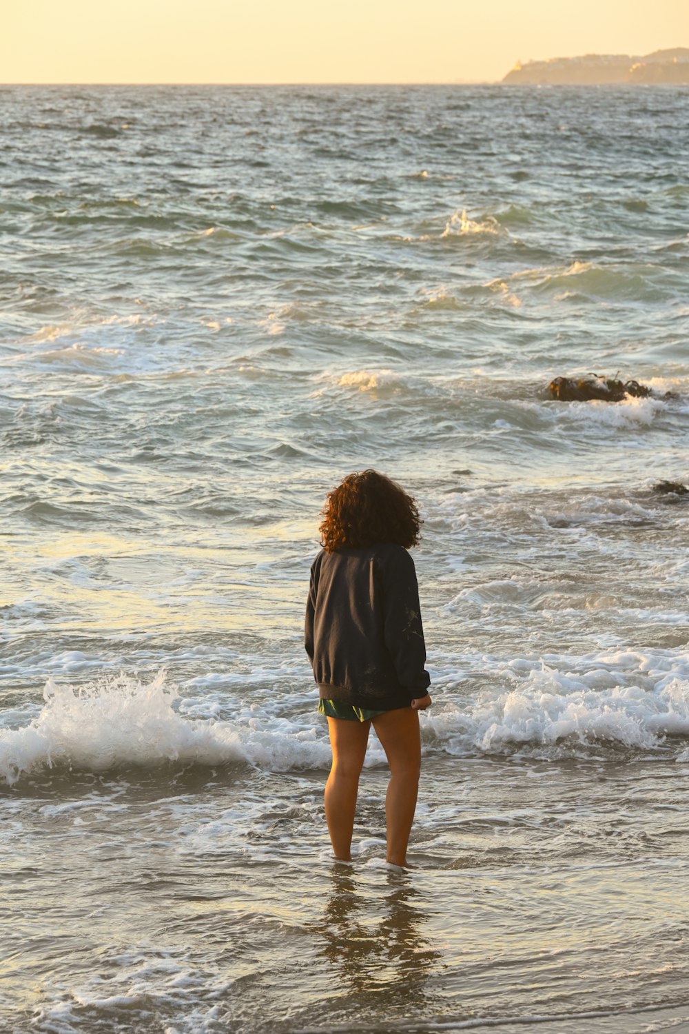 a woman standing in the water at the beach