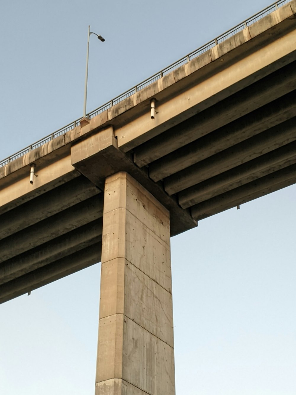 a traffic light on a pole under a bridge