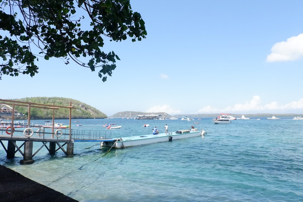 a pier with boats in the water and a sky background